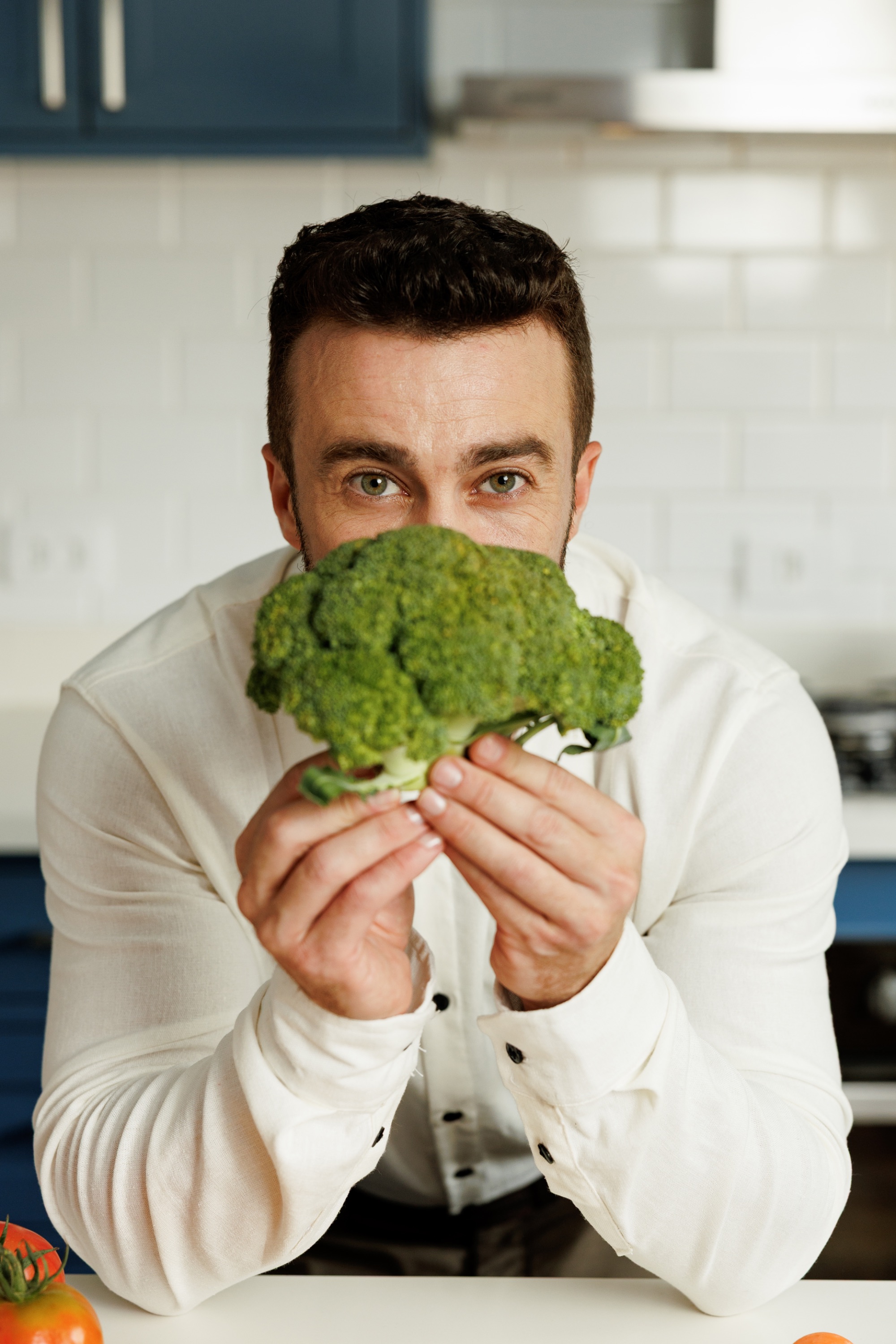Thales Rosa, nutricionista, com brócolis na cozinha
